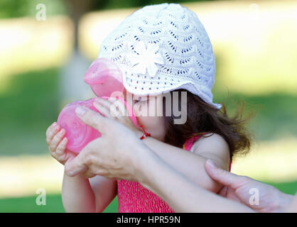 Adorable young children drinking water from a nursing bottle Stock Photo