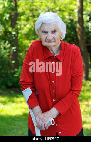 Handicap elderly woman using a crutch to walk Stock Photo