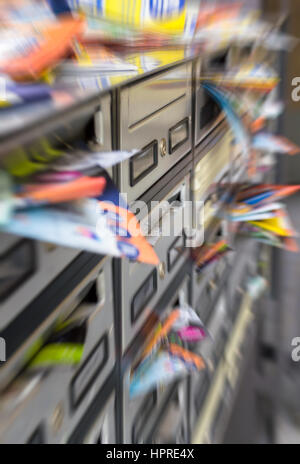 Mailboxes filled with paper flyers. Symbol for advertising, mail, marketing, spam. Defocused blurry background. Stock Photo