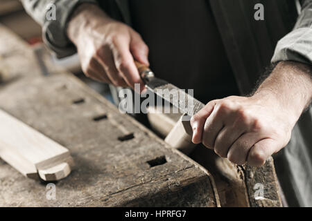 Carpenter working on a piece of wood with a file Stock Photo