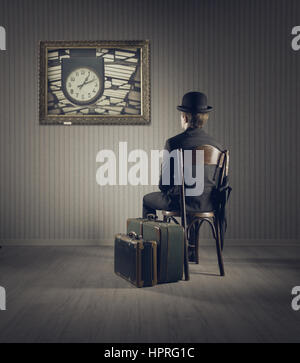 Business man sitting on old chair,  checking time for his travel Stock Photo