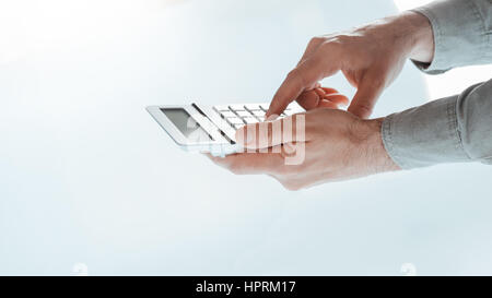 Businessman's hands using a calculator close up, white desk on background Stock Photo