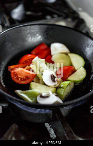 Cooking many different veggies pepper, tomato, summer squash in the frying pan Stock Photo