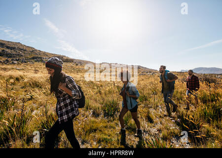 Group of young people on country walk. Young men and women hiking on a summer day. Stock Photo