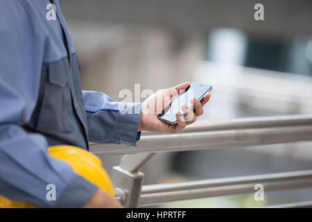 Engineer, Foreman hands with smart phone in modern city Stock Photo
