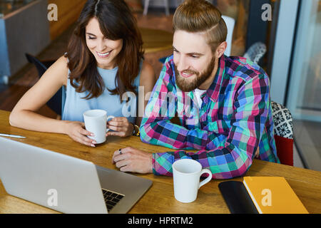 Friends working with laptop on new startup ideas in cafe Stock Photo