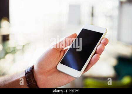 Close-up of smartphone with empty screen held by men Stock Photo