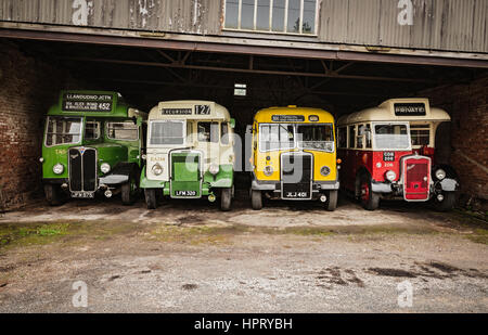 Four vintage buses parked inside a garage Stock Photo