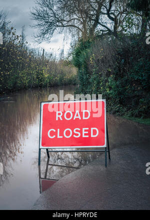 Flooded country road with warning sign Stock Photo - Alamy