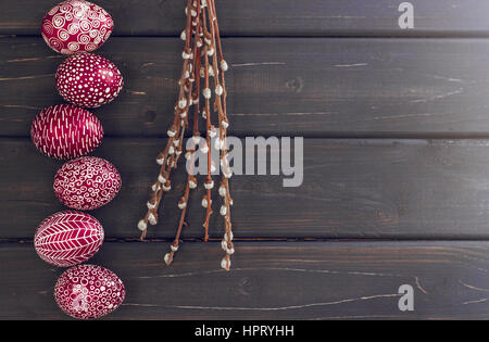 Still life with Pysanka, decorated Easter eggs, dry willow branches on black wooden background, top view, copy space Stock Photo
