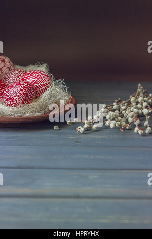 Still life with Pysanka, decorated Easter eggs, dry willow branches on black wooden background, copy space Stock Photo