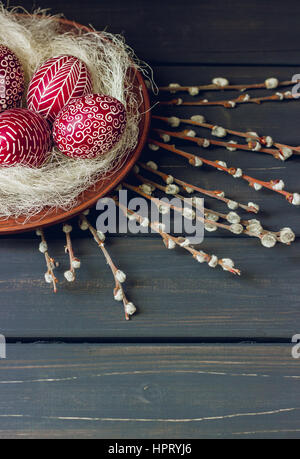 Still life with Pysanka, decorated Easter eggs, dry willow branches on black wooden background, copy space Stock Photo
