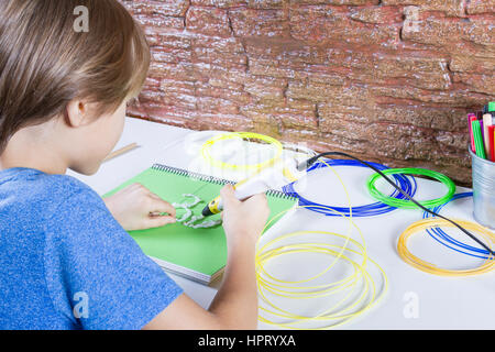 Child using 3D printing pen. Boy making new item. Creative, leisure, technology, education concept Stock Photo