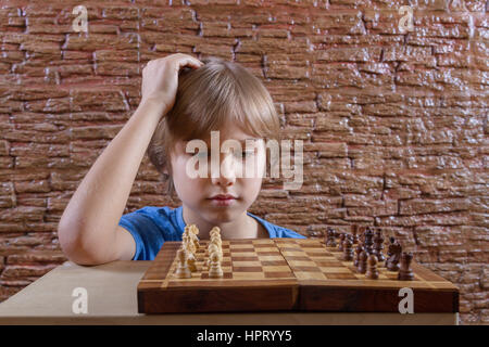 Child looking at chess board and planing new game Stock Photo