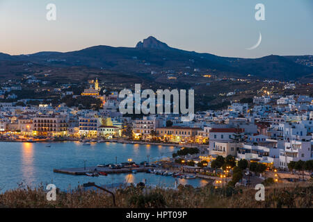 Tinos city and harbor in the afternoon with the moon rising above the sky Stock Photo