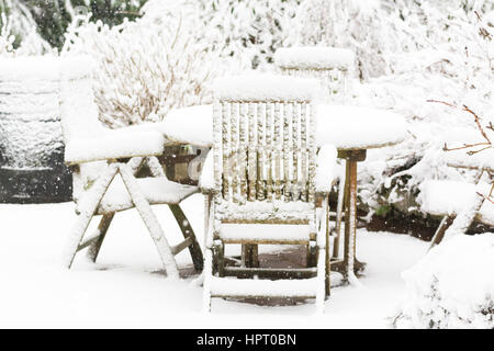 garden in snow - garden furniture, table and chairs covered in deep snow Stock Photo
