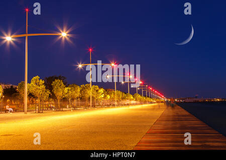 Thessalokini, Greece seafront with lights and reflections in the evening and the moon rising above the sky Stock Photo