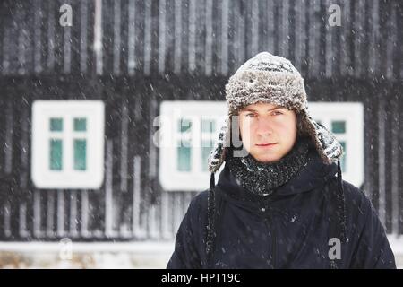 Portrait of young man outdoors in winter under snowstorm Stock Photo