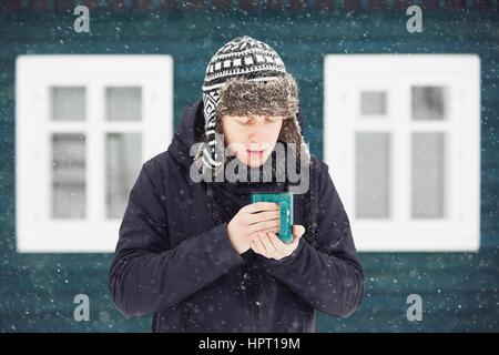 Portrait of young man outdoors in winter under snowstorm Stock Photo