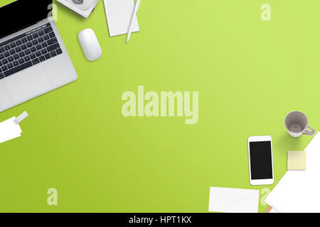 Office accessories on green desk. Free space for text. Laptop computer, papers, smart phone, mug; pen, mouse beside. Stock Photo