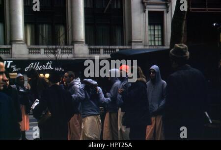 A crowd gathers, possibly in protest, outside Albert's in the Bronx, New York City, New York, with some wearing hoodie sweatshirts, 1971. Stock Photo