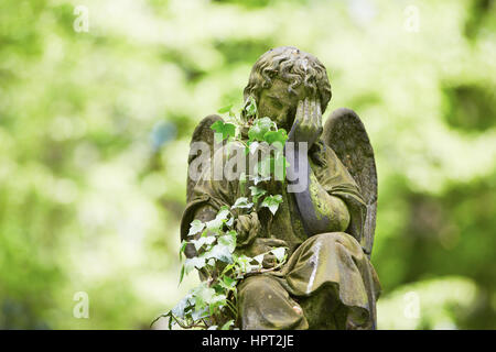 Sad angel statue on old cemetery Stock Photo
