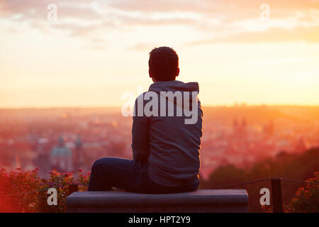Young man is looking at the sunrise. Stock Photo
