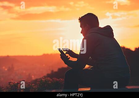 Young man with phone at the sunrise. Stock Photo