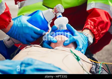 Cardiopulmonary resuscitation. Rescue team (doctor and a paramedic) resuscitating the man on the street. Stock Photo