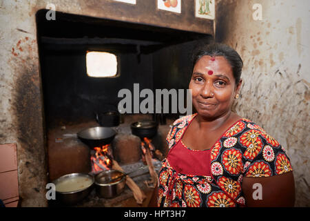 Woman is preparation food in ancient kitchen - Poverty life in village in Sri Lanka Stock Photo