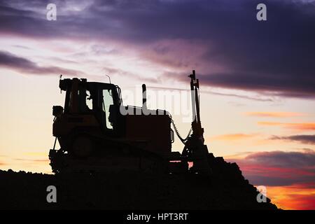 Silhouette of the bulldozer in the building site Stock Photo