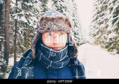 Handsome man is standing on the snowy road. Stock Photo