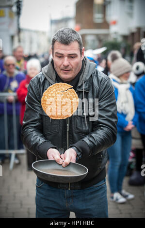 A competitor flips a pancake during a charity pancake flipping contest in Littlehampton, West Sussex, England, UK. Stock Photo