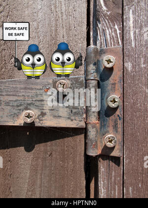 Comical bird construction workers perched on an old rusty hinge with health and safety message work safe be safe sign Stock Photo