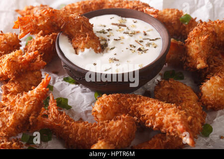 prawns fried in coconut close-up and cream sauce on the parchment on the table. horizontal Stock Photo