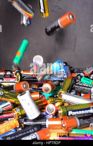 throwing old AA and AAA batteries into recycling box Stock Photo