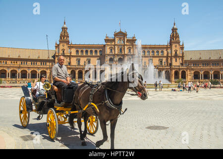 SEVILLE - APRIL 20: tourists ride on horse carriage around plaza de espana Sevilla on April 20, 2015 in Seville, Spain. Stock Photo