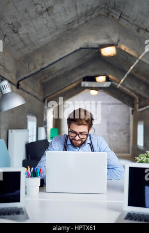 Designer working on laptop at creative agency office Stock Photo