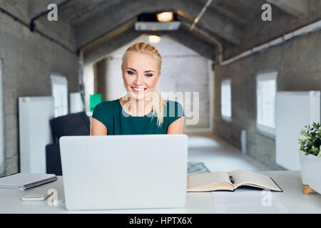 Happy businesswoman working on laptop in modern office, start up, new business concept Stock Photo