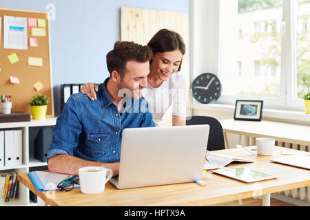 Happy couple running business together working with laptop from office Stock Photo