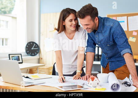 Happy couple working together in designers, architects office Stock Photo