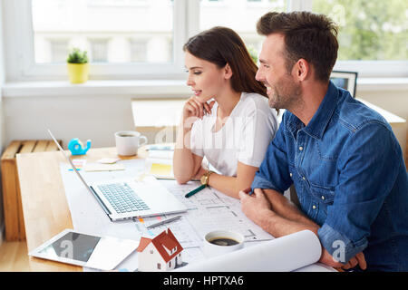 Two designers architects working together with laptop sitting at table Stock Photo