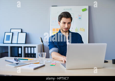 Web designer working on laptop in office Stock Photo