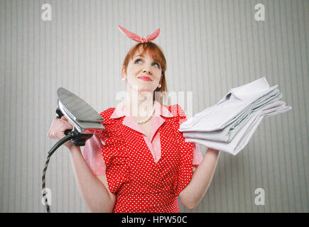 Perfect housewife with iron and ironed shirts Stock Photo