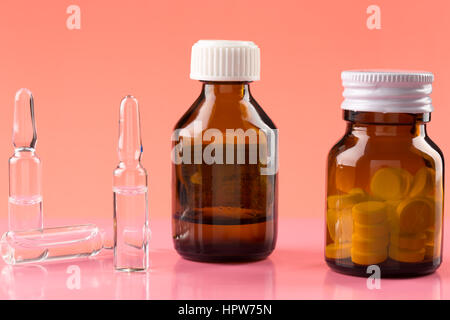 Brown glass pill bottles and three medicine ampules Stock Photo