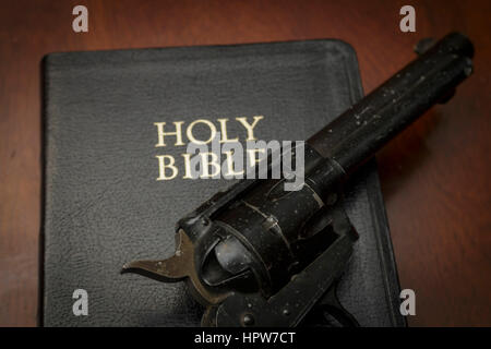 gun on a bible Stock Photo