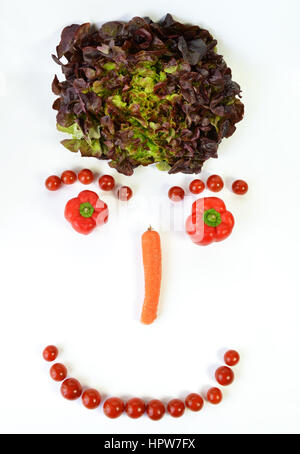 A smiley face, with vegetables, salad, peppers, carrots, tomatoes. Stock Photo