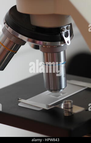 high power objective lens and microscope slide on microscope stage Stock Photo