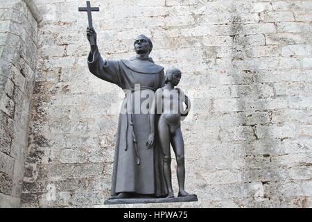 Junipero Serra religious statue in the Saint Francis of Assisi square. Catholic figure holding a a Christian cross and a young boy Stock Photo