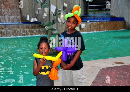 Baltimore, Maryland - July 22, 2013:  Two adorable children with balloon hats at a Pratt Street fountain Stock Photo